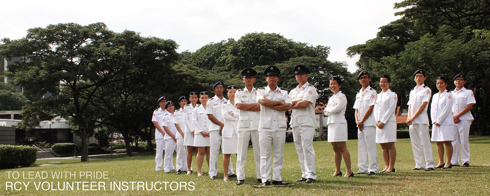 A Red Cross Youth volunteer instructor standing with young cadets in uniform.